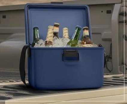 Navy hardshell cooler box filled with bottles in the back of a truck