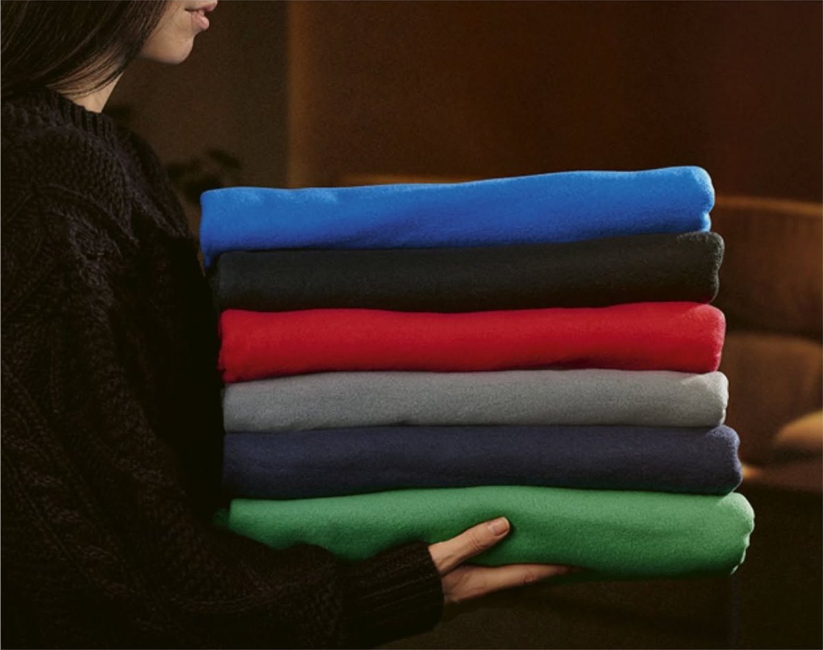 Stack of folded fleece blankets in blue, black, red, grey, navy and green