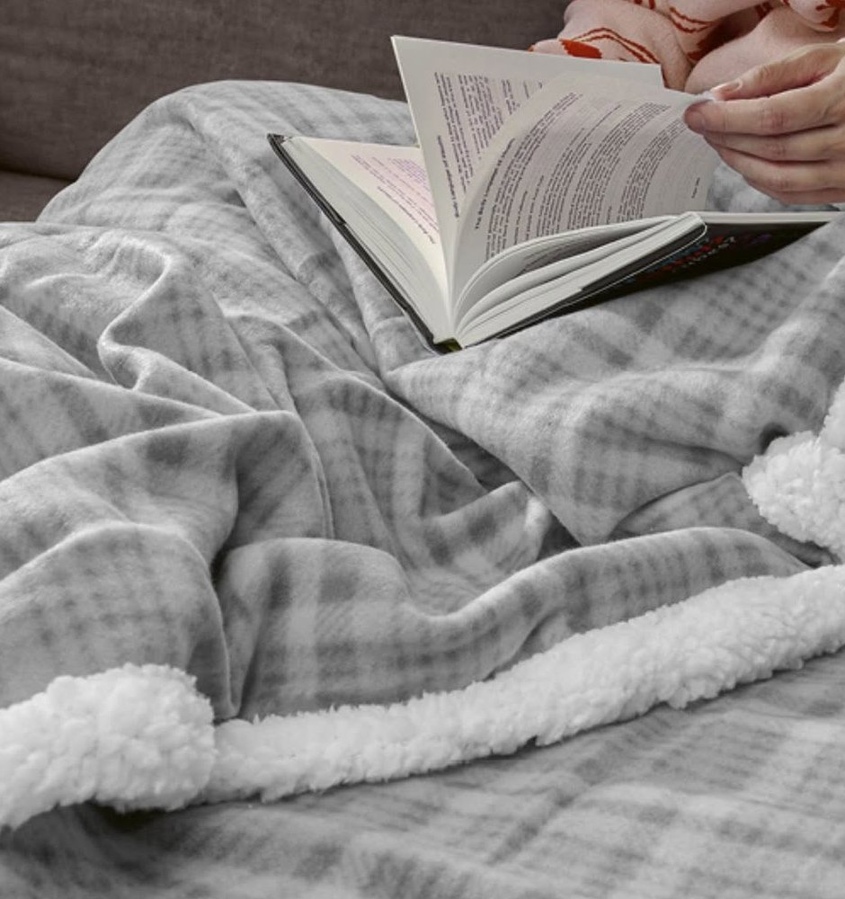 Grey check fleece blanket with a soft sherpa lining and a book resting on top